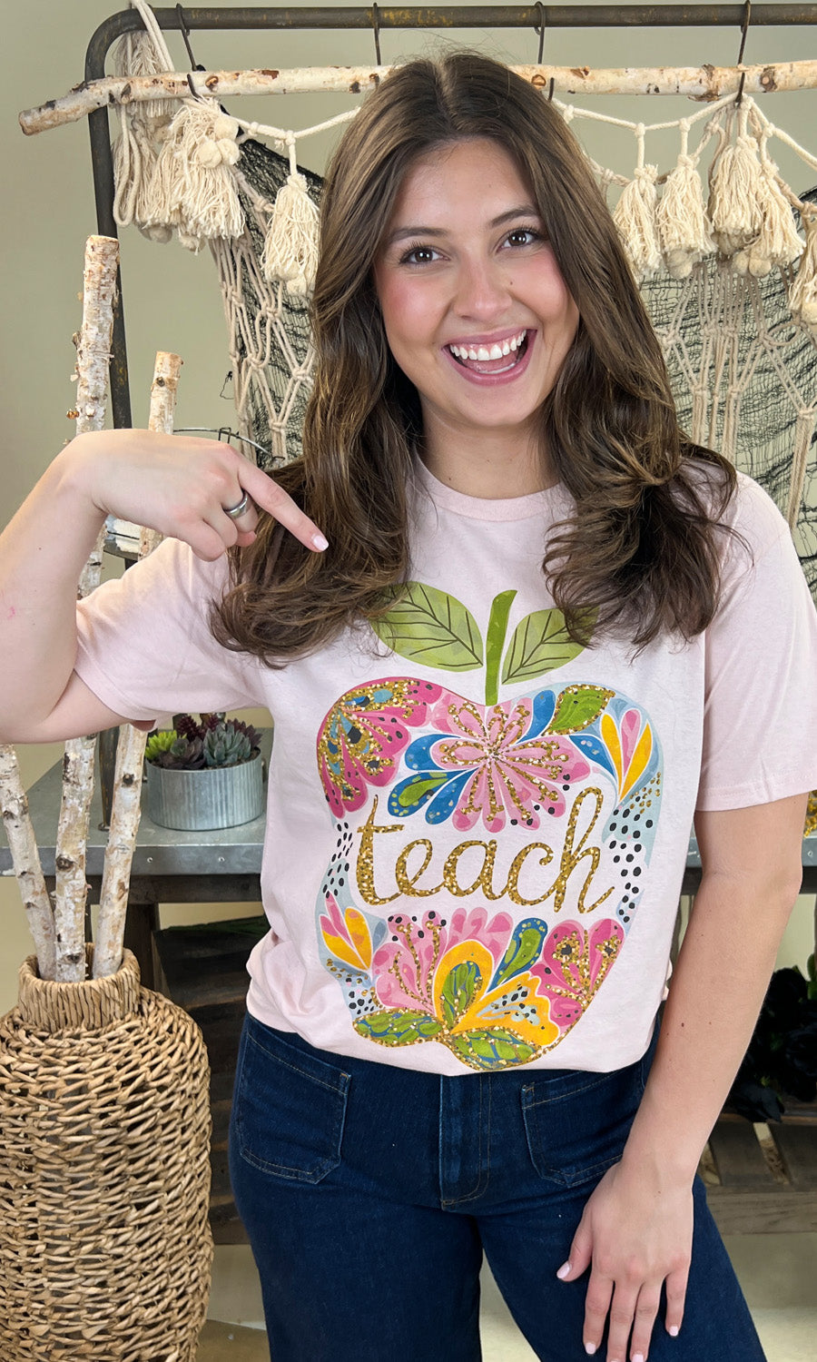 Stylish Floral Glitter Apple Teacher Graphic Shirt worn by a smiling woman, perfect for educators and back-to-school.