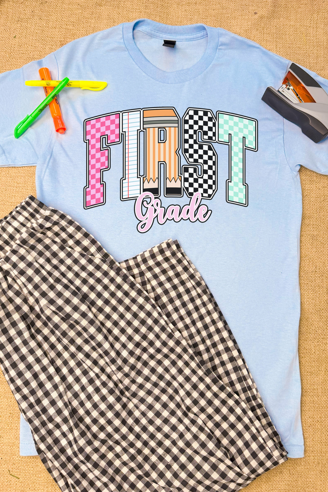 Stylish Checkerboard Grade Level Graphic T-Shirt in blue, perfect for first graders, paired with trendy checkered pants.