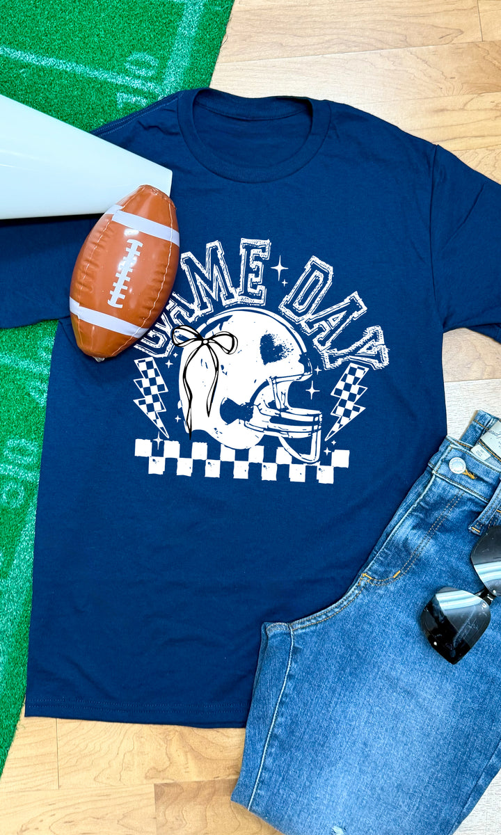 Navy Game Day Football Bow Graphic T-Shirt styled with football and jeans, perfect for game day celebrations.