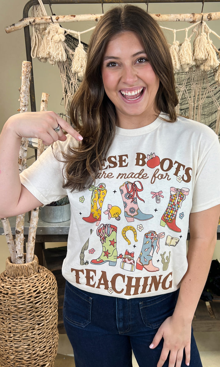 Stylish woman wearing the These Boots Were Made For Teaching Graphic Shirt, showcasing fun boot designs and a teaching theme.
